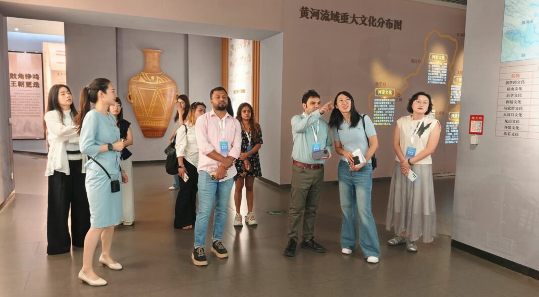 国际参访团在黄河文化馆仔细聆听讲解 摄影 王宪鑫